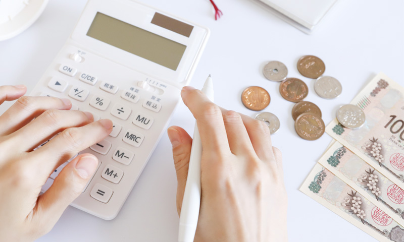 電卓で金額を計算する人のイメージ写真